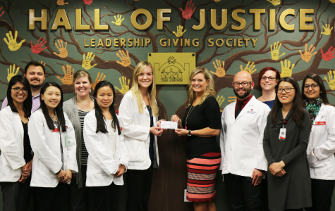 Pharmacy students present a check to The Bridge
