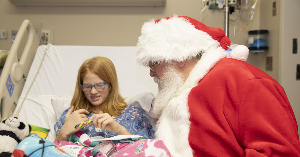 Santa shares present with little girl 