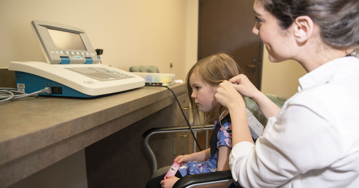 TTUHSC speech language pathology student setting up equipment to evaluate patient.