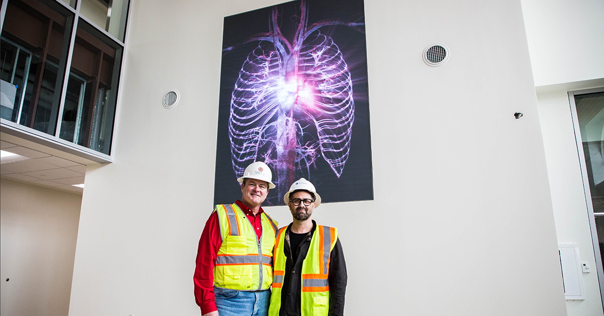Ted Mitchell, M.D., and artist stand in front of "Pulse."