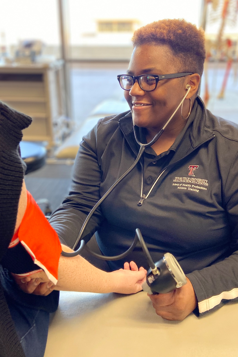 TTUHSC athletic training student getting a blood pressure reading on a patient.