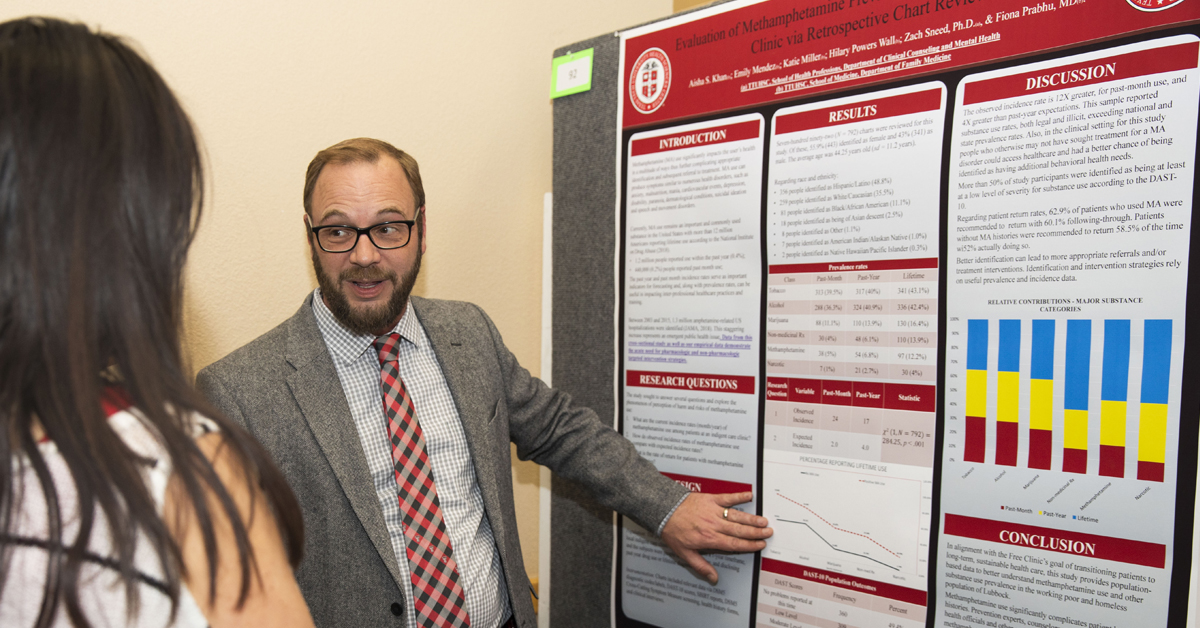 TTUHSC substance abuse counselor discussing his research finding and utilizing an informative poster.