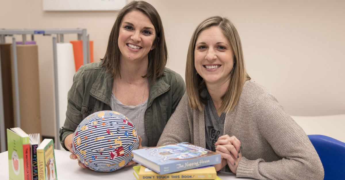 TTUHSC speech language pathology students at a table with books and resource materials.