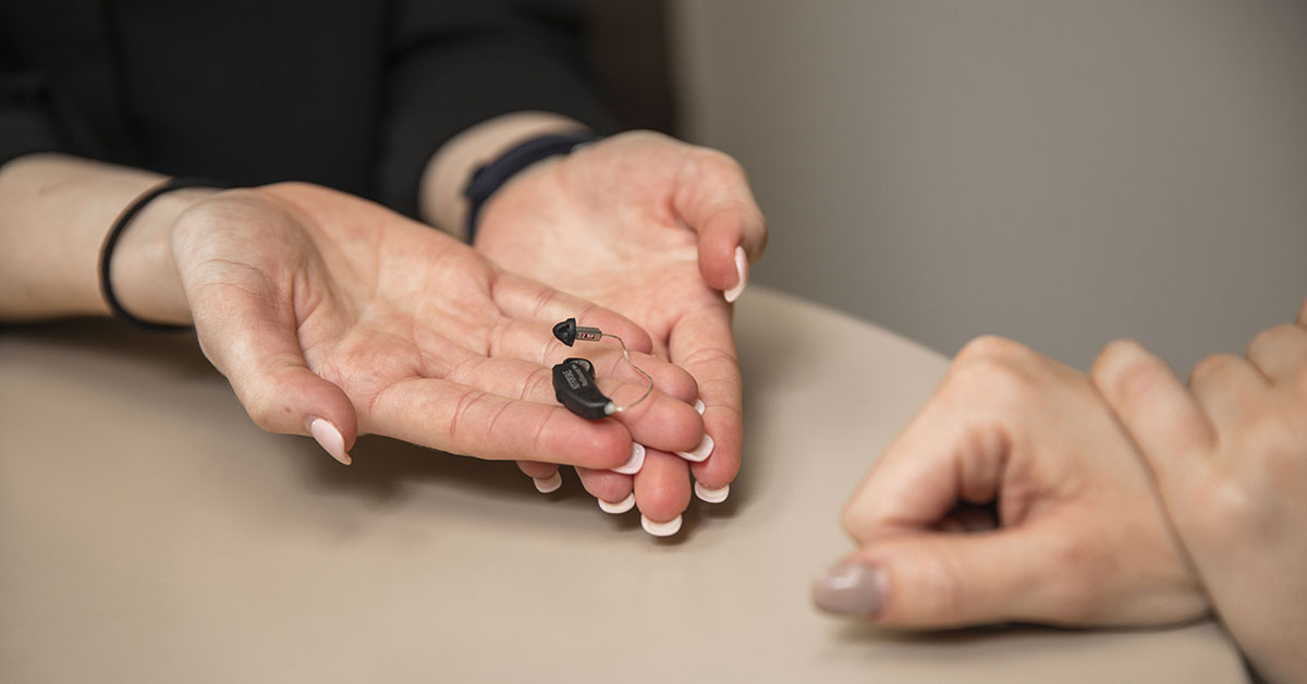 hands holding hearing aids