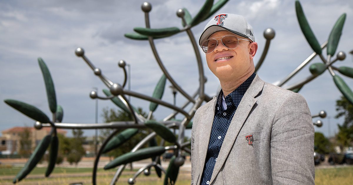 Duke Appiah, Ph.D., standing in front of TTUHSC statue on Lubbock campus