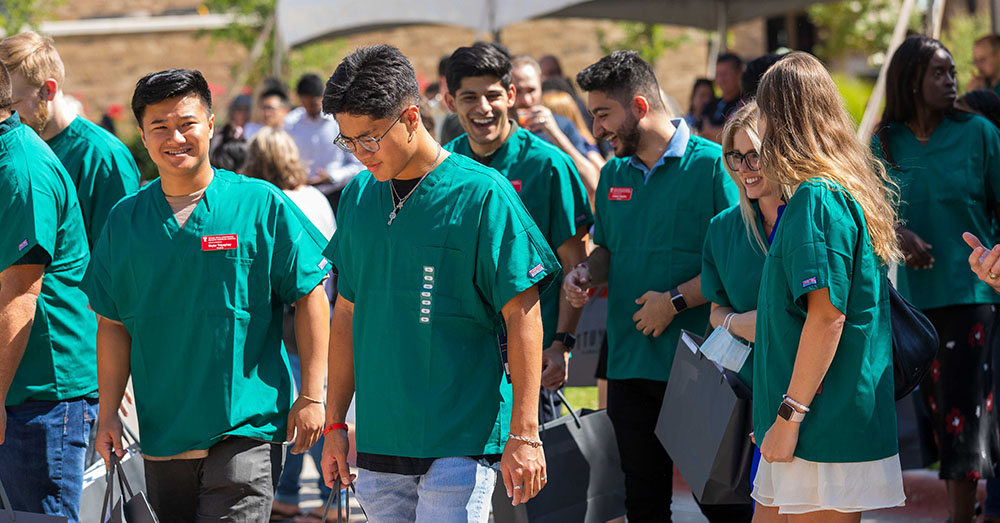 students wearing new green scrubs at Scopes and Scrubs event