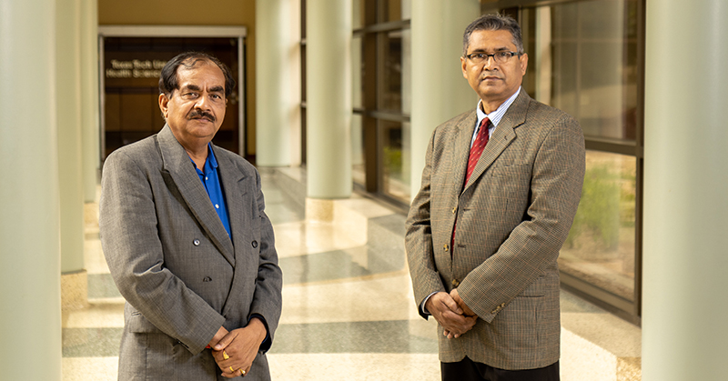 P. Hemachandra Reddy, Ph.D. and Hafiz Khan, Ph.D. standing in the hallway at TTUHSC