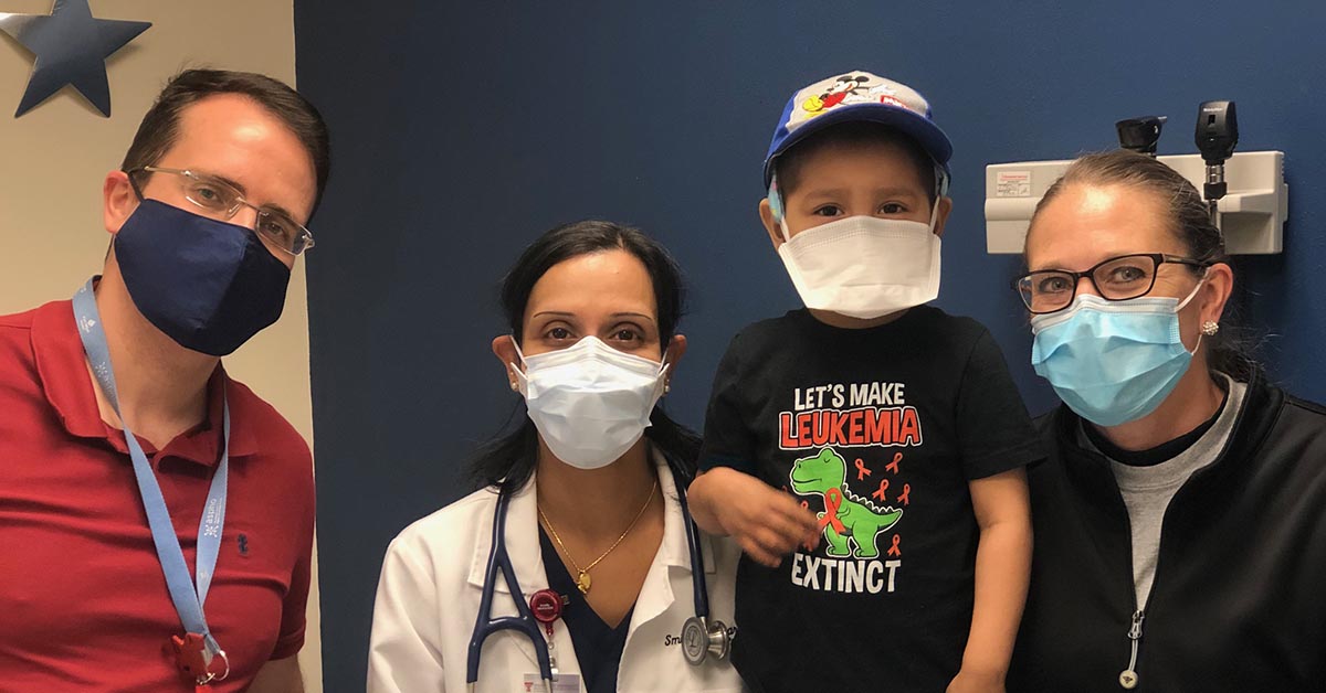 Logan and his family and oncologist in masks