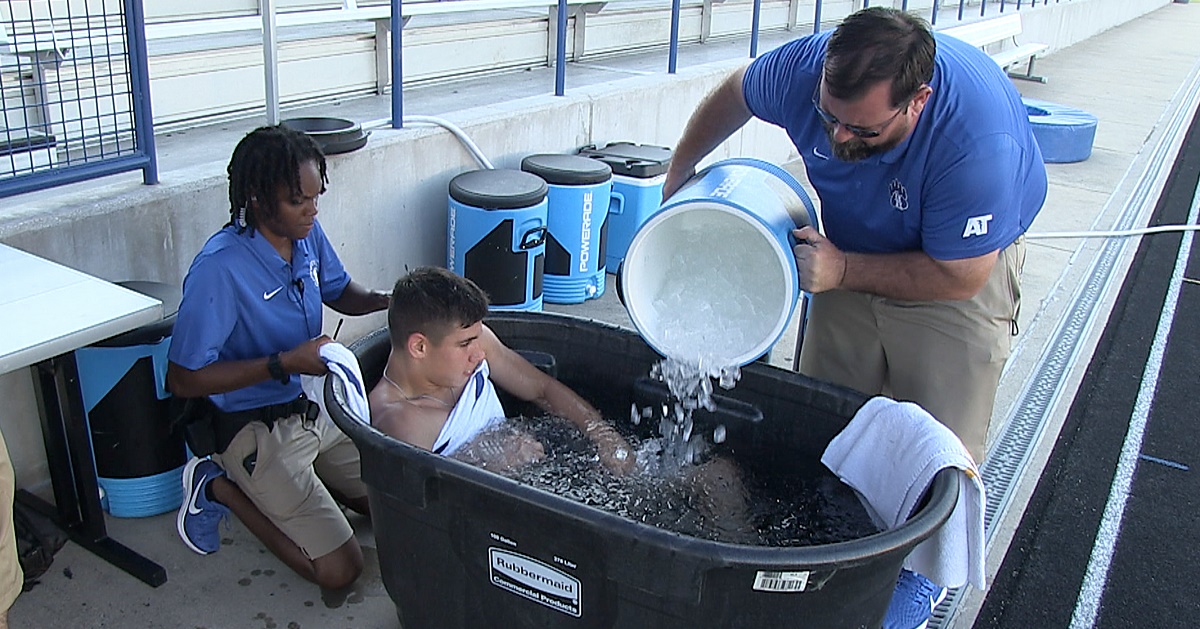 athletic trainers giving a patient an ice bath
