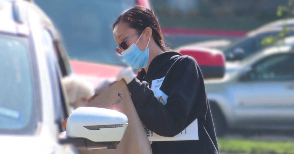 woman with mask accepting medication to dispose at the Amarillo medication cleanout