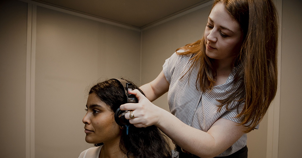 health care professional putting headphones on a patient