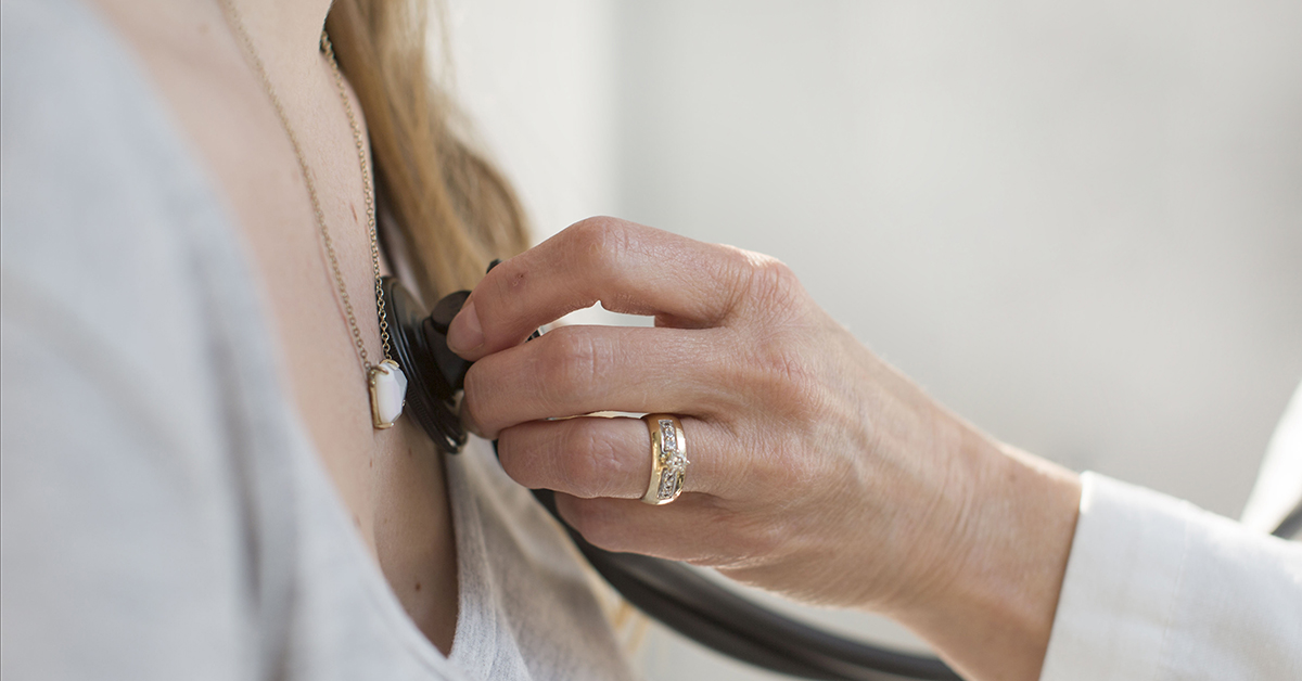 hands checking a patient with a stethoscope 