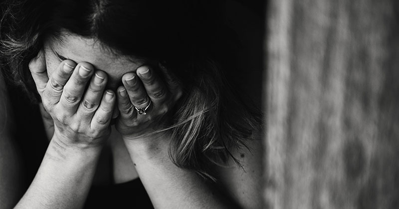 distressed woman with her head in her hands