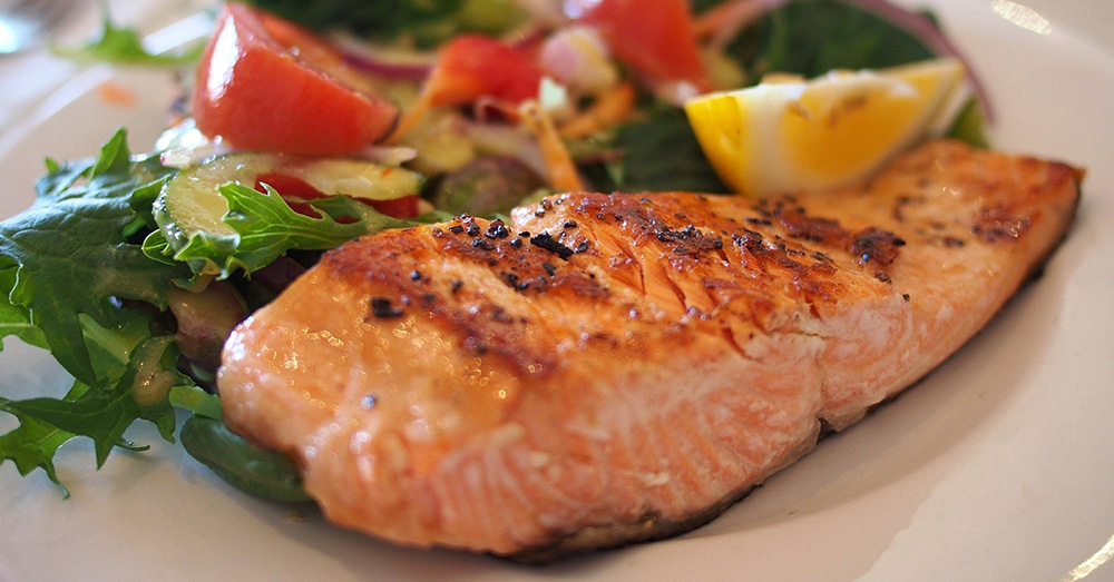 cooked salmon on a plate with vegetables