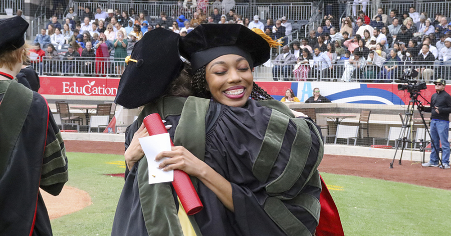 graduate hugging after receiving her diploma