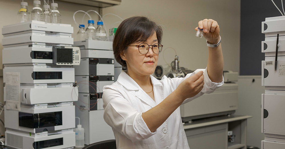 Min Kang, Pharm.D., working in a lab