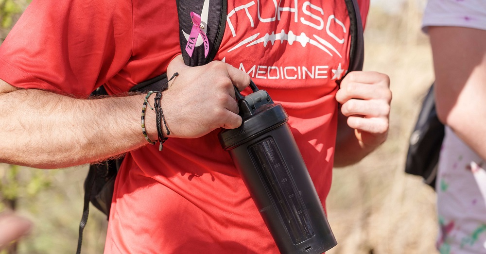close up of man hiking with "TTUHSC Medicine" on his t-shirt