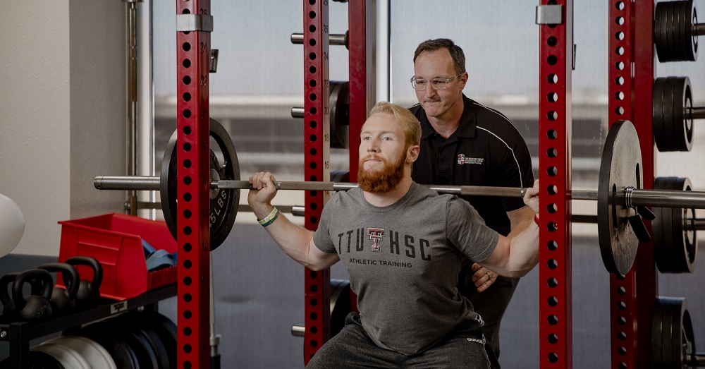 Toby Brooks, Ph.D. helping an athlete 