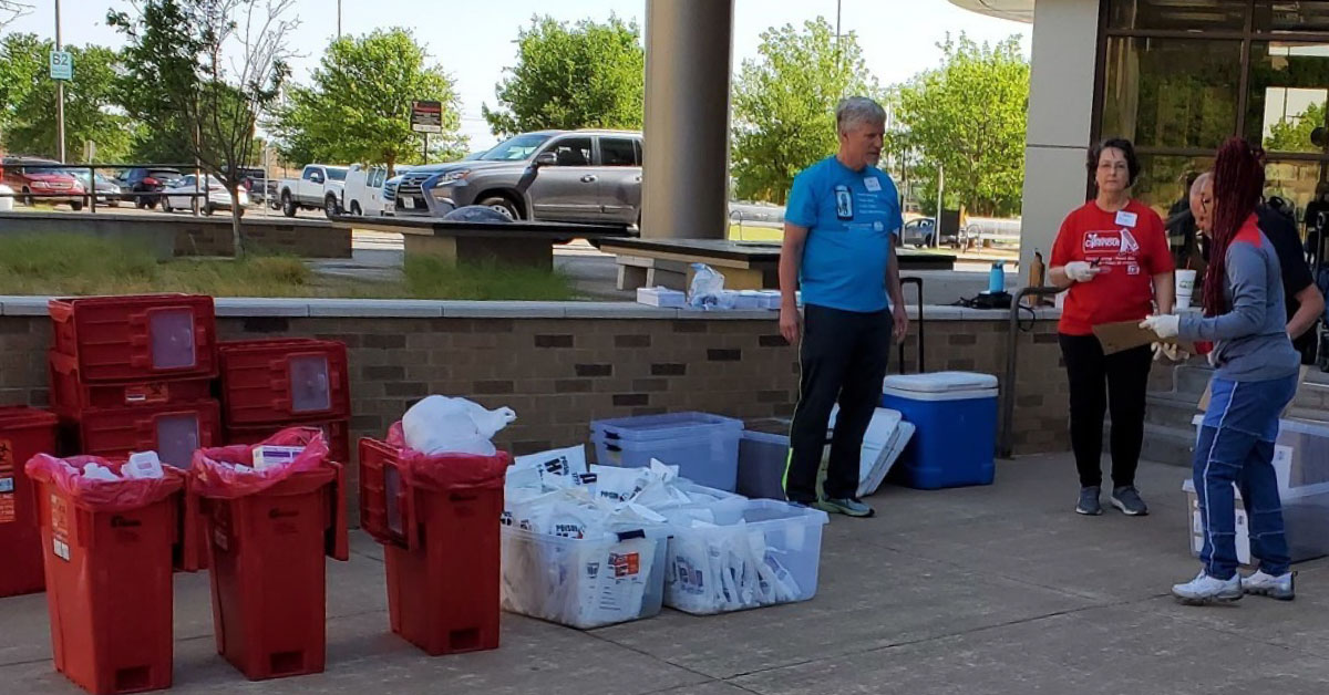 volunteers standing near medication that is has been handed off during medication cleanout 
