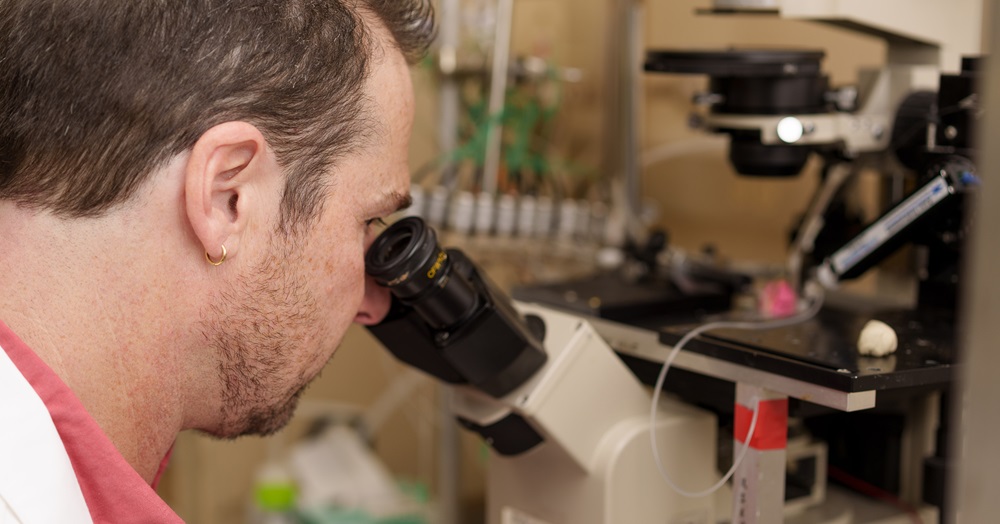 Pablo Artigas, Ph.D., looking into a microscope