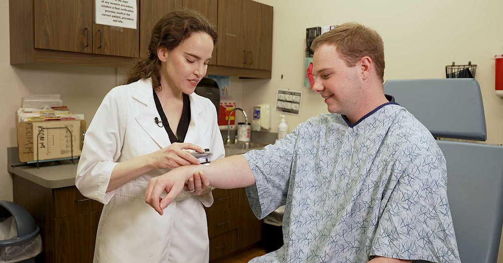 doctor examining skin on a patient's arm