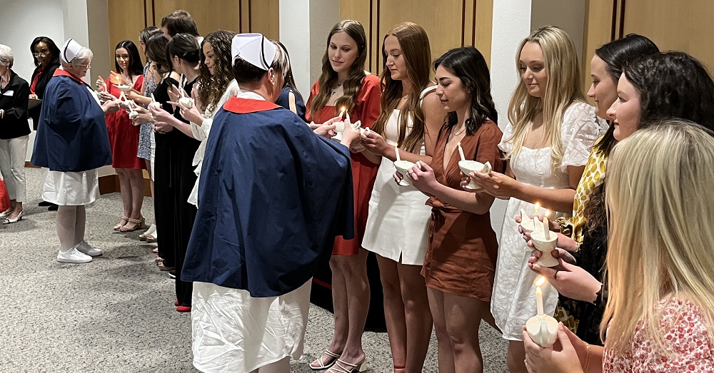 BSN students stand in a line with candles for lamp lighting ceremony 