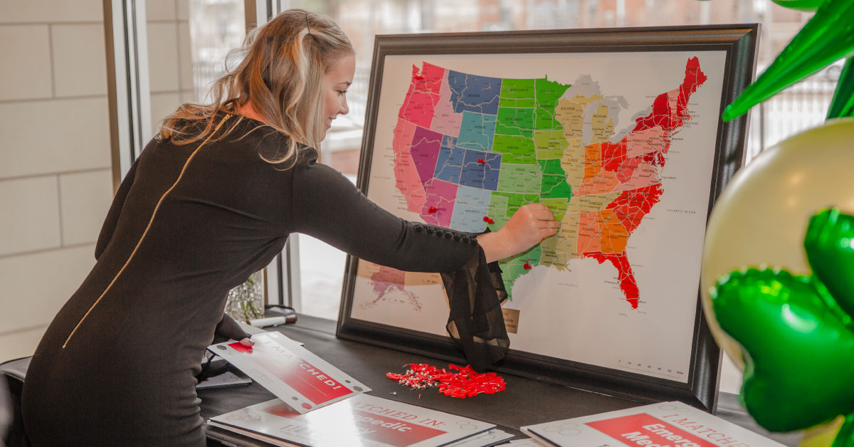 Female TTUHSC medical students pins where she matched for residency on a map of the United States.