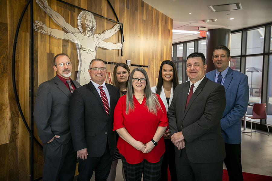 Seven people stand in front of the TTUHSC Institute of Anatomical Sciences