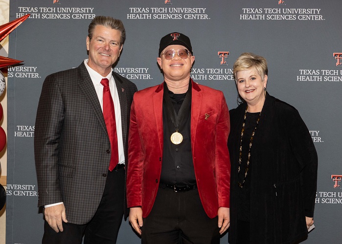  three people stand in front of a TTUHSC step and repeat