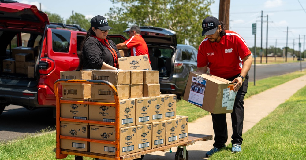 People in TTUHSC caps unload boxes from a van