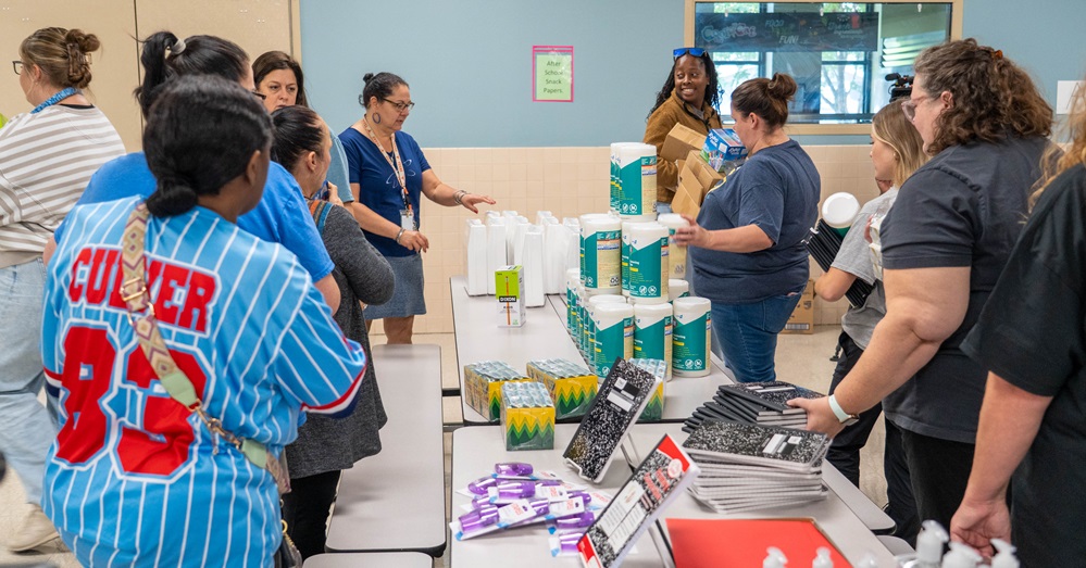 People unload school supply donations into an elementary school