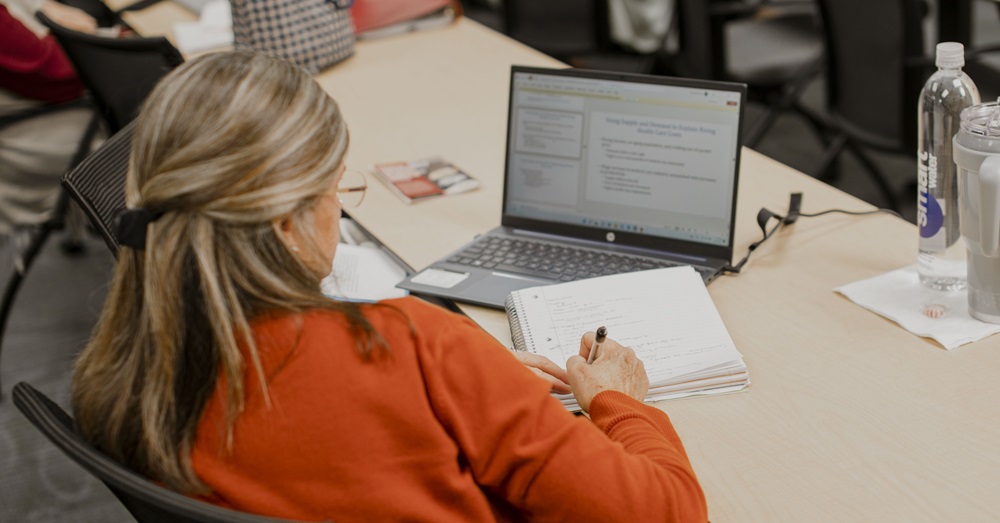 woman studying with a notebook and laptop