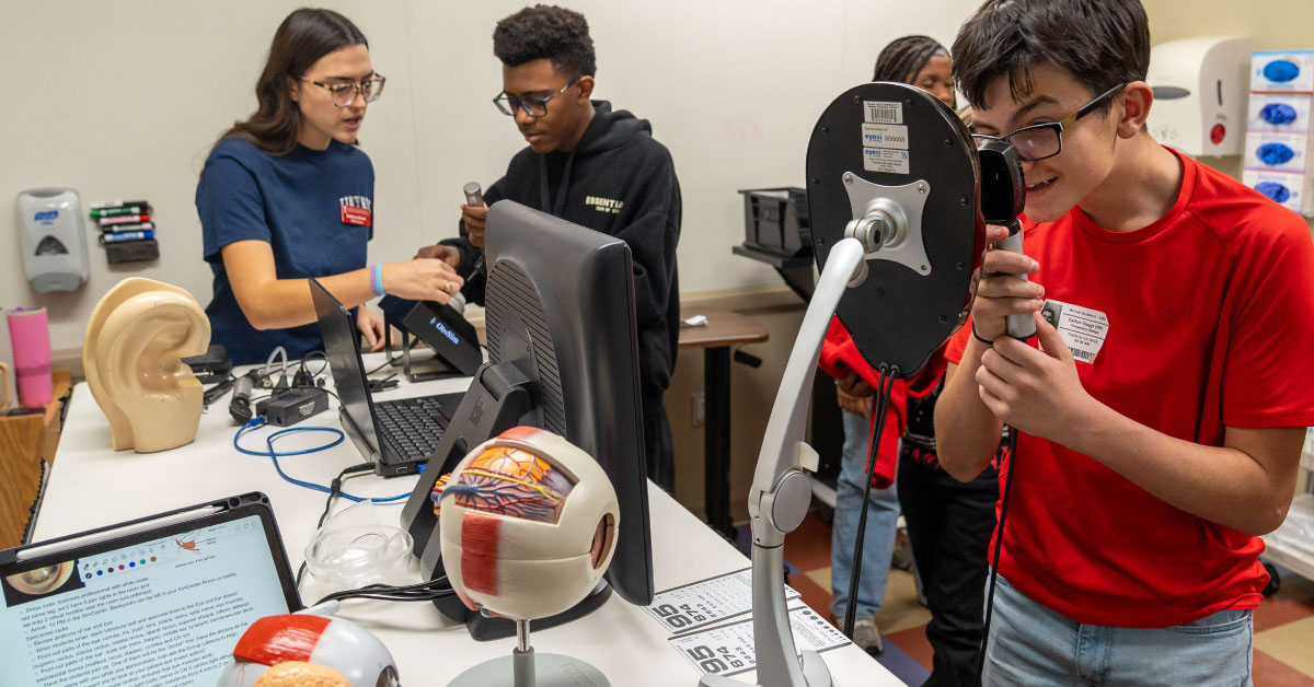 Middle school students look into medical vision devices.
