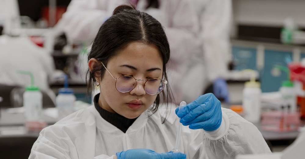 woman in lab working with a vile 