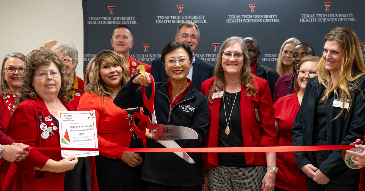 Adminstrators cut ribbon at a press confernce.