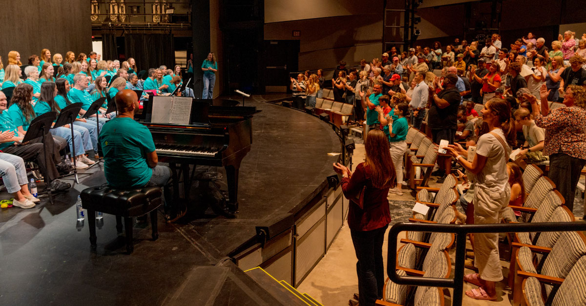 Audience cheers for performers on stage at a concert.