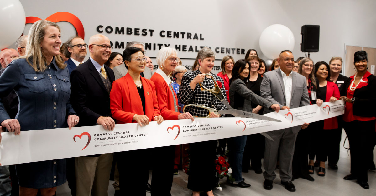 Large group of TTUHSC adinistrators cut a ribbon.