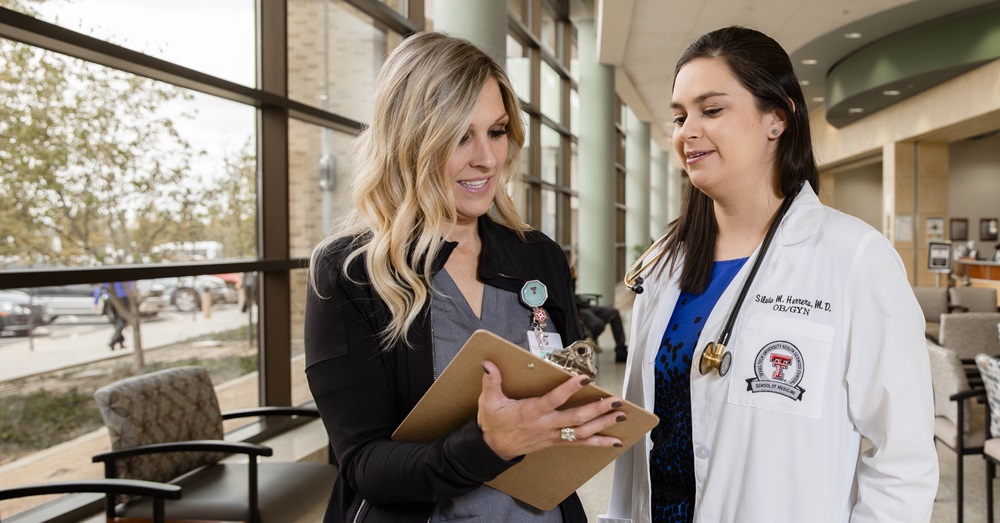 two health professionals discuss results on an ipad