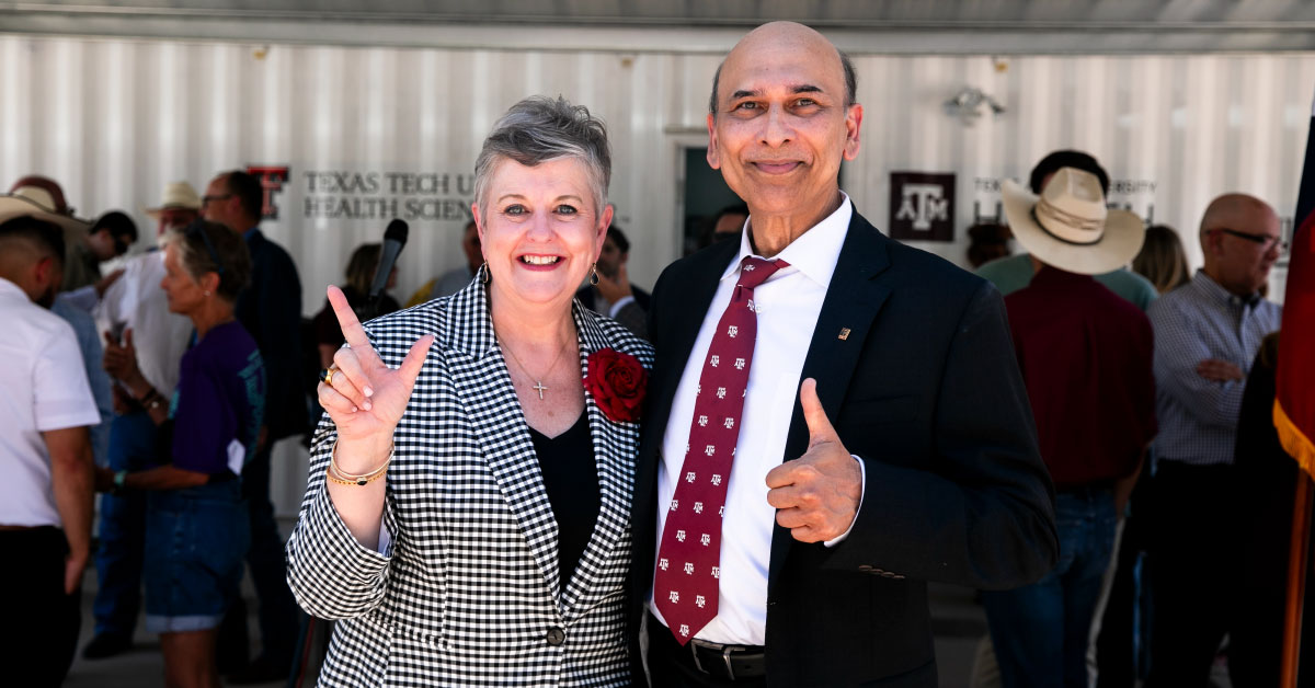 Man and woman pose together at a press conference.