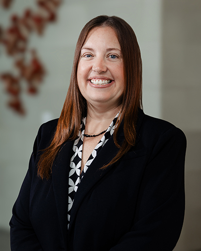 Woman TTUHSC nursing dean smiles wearing black coat.