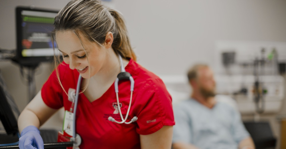 nurse in red scrubs smiling