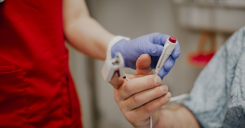 close up of a hand taking vitals on another hand in a health care setting