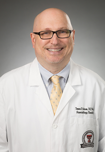 Male TTUHSC researcher wears a white coat and glasses.