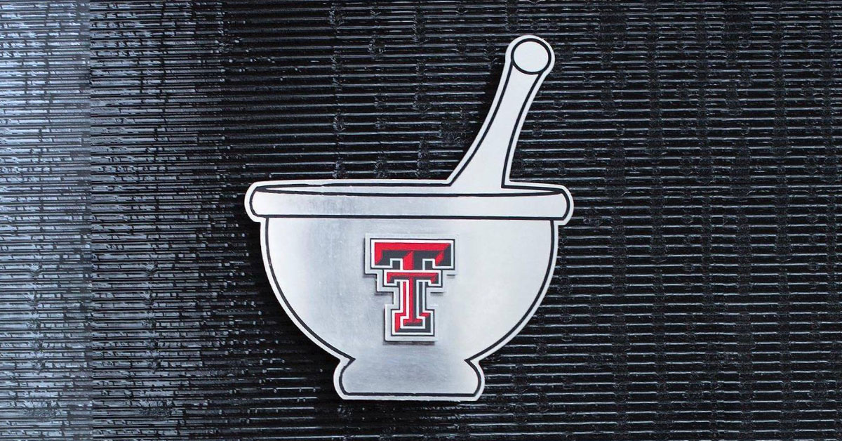 Double T logo on a flat, metal mortar and pestal.