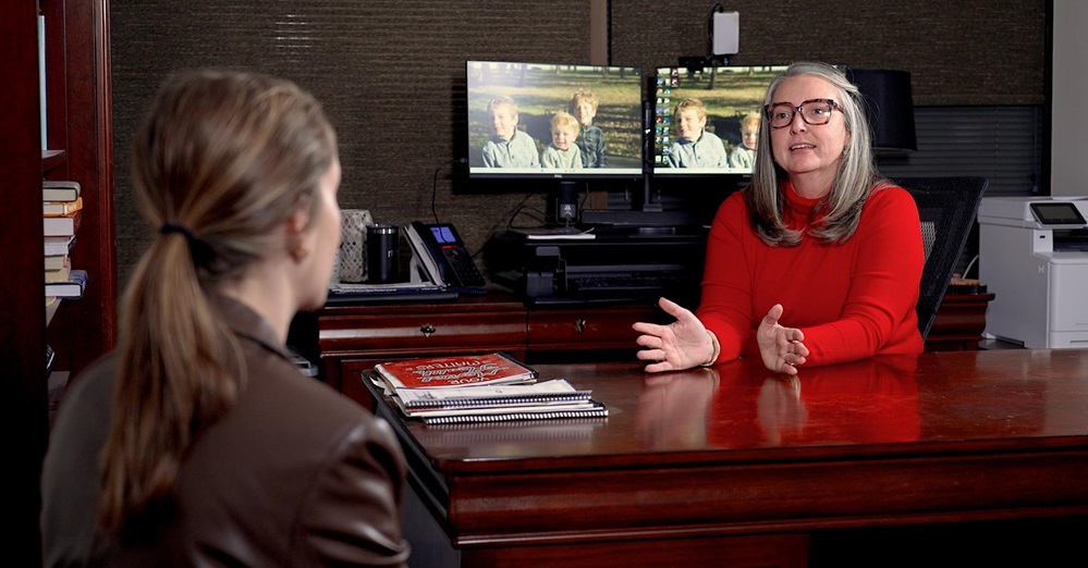 Two women talking across a desk