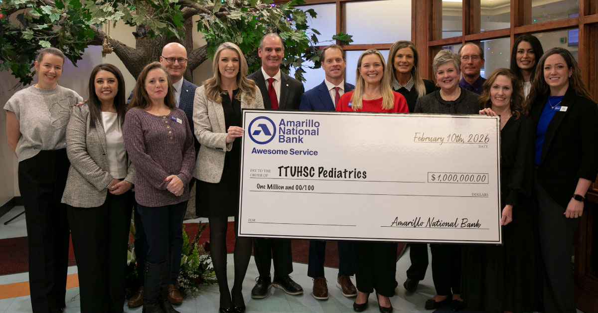 Large group of people holds a large check.