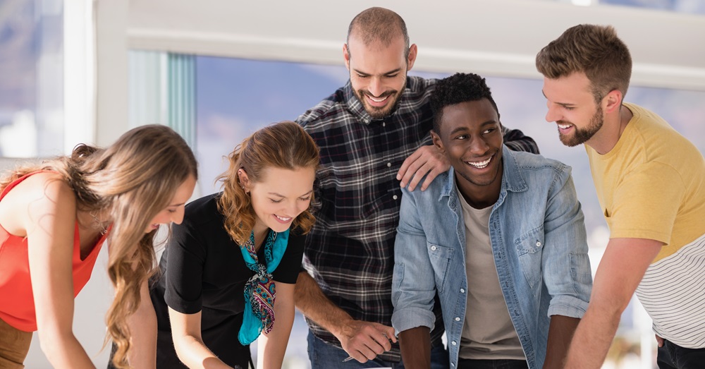 group of people working around a computer