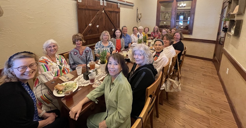 The School of Medicine Faculty Women's Club seated at a table