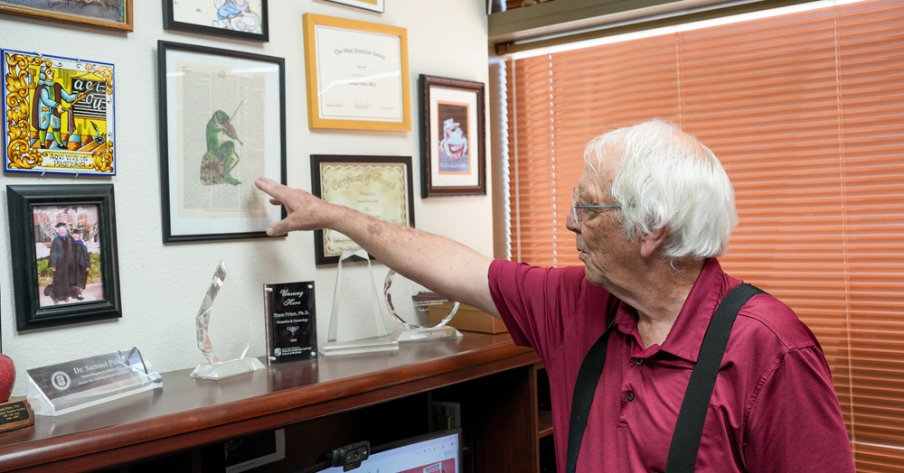Dr. Prien points to a piece of art on the wall