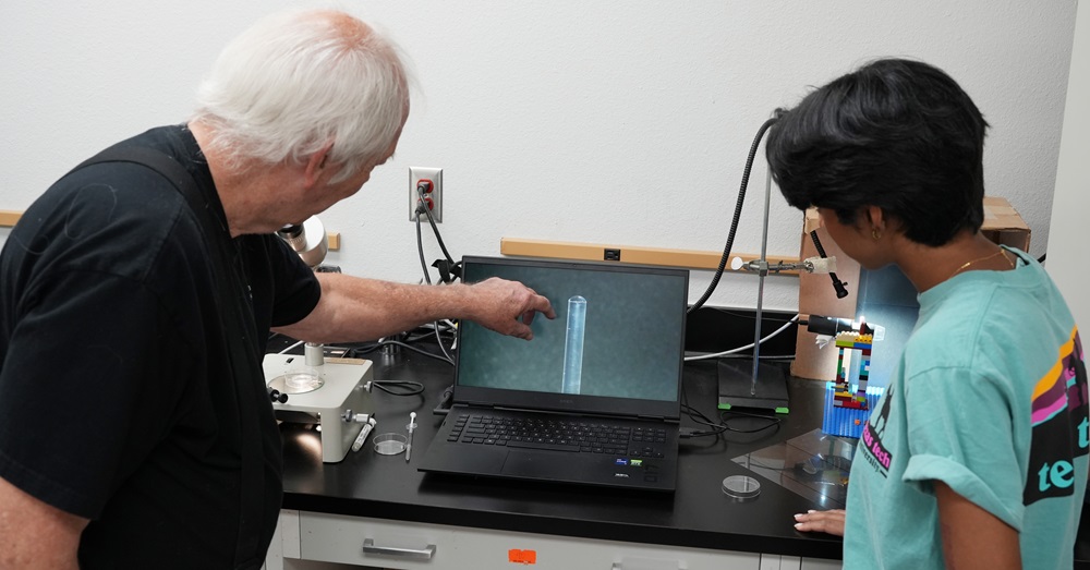 Dr. Prien and a student look at a screen together in a lab setting.